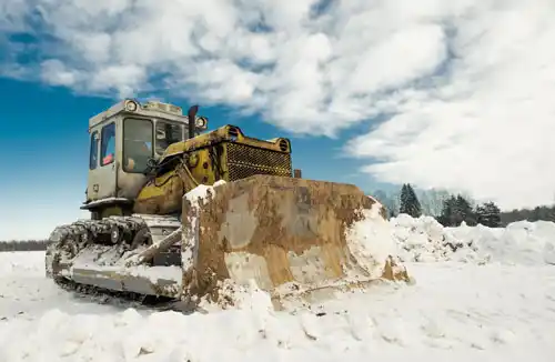 yellow-crawler-tractor-bulldozer-with-bucket-works-winter-clearing-road-from-snow